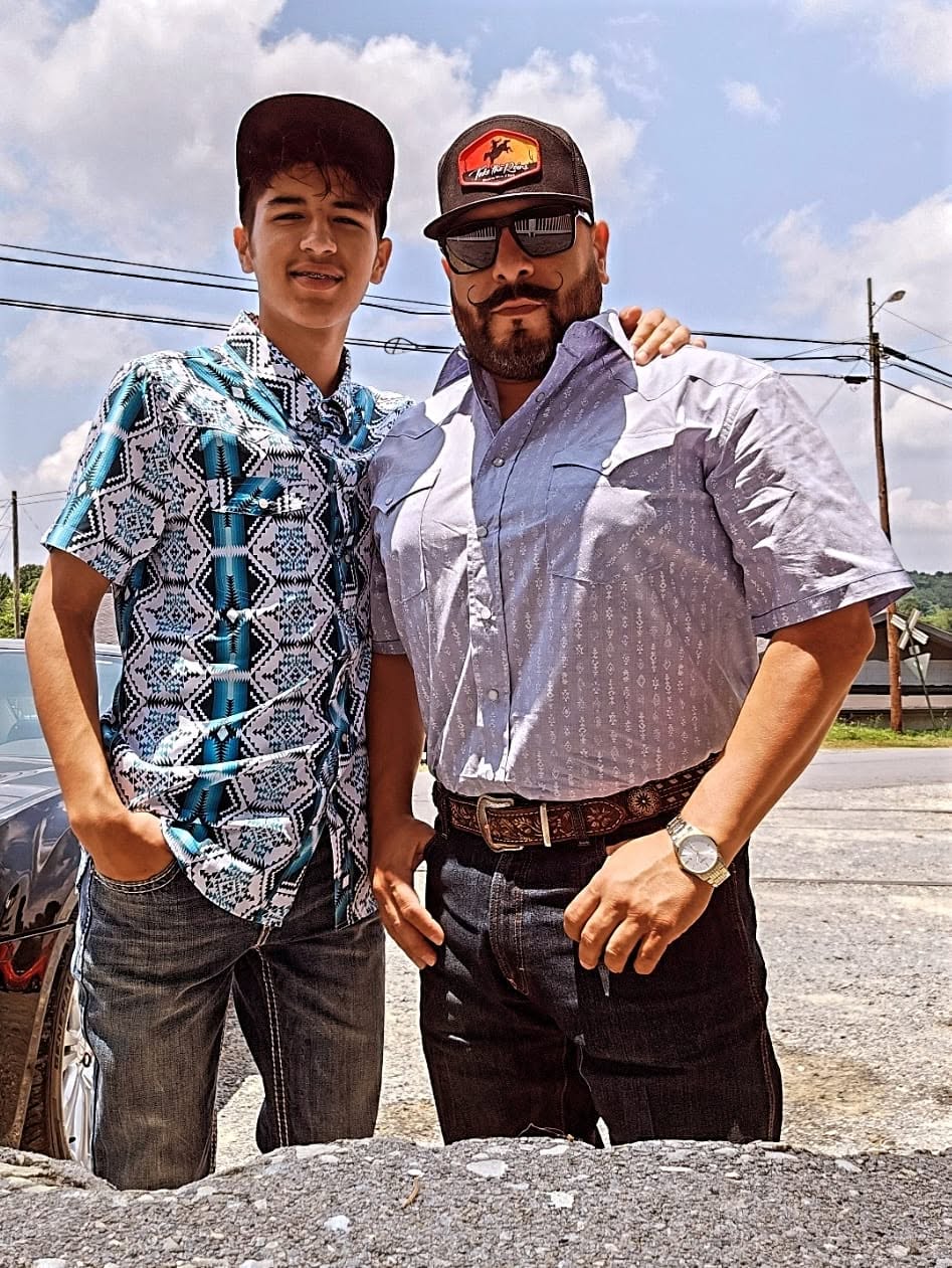 Tex Ruiz and his son Ely outside the store in western shirts and denim