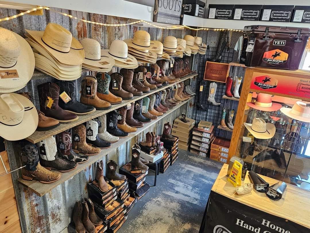 Rows of cowboy boots and straw hats on the tin-walled shelves inside Take the Reins